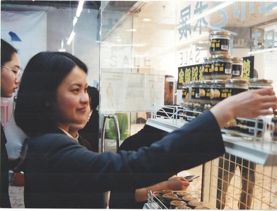 　　1999年4月10日“超市”展的第一天，一位观众正在拿起朱昱作品《全部知识学的基础》——一瓶死人脑汁做成的浆糊。
